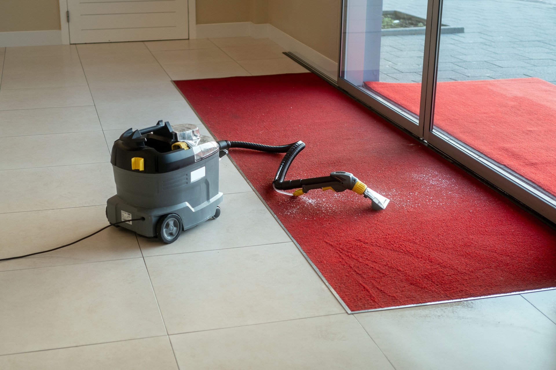 Carpet cleaning with vacuum in modern interior